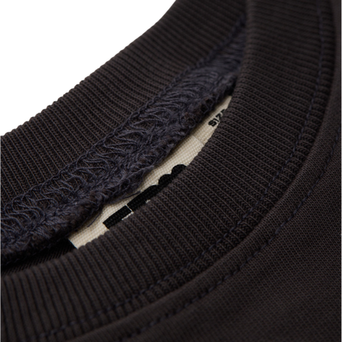 Close-up of a black long sleeve black t shirt collar with ribbed texture