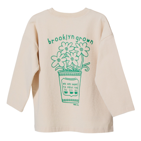 Beige long sleeve t shirt with green floral graphic and text on a white background