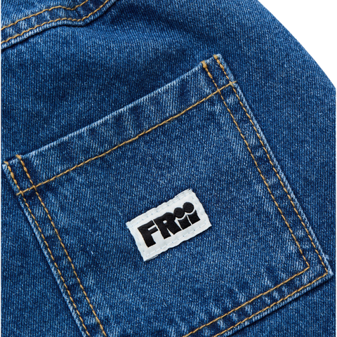 Close up of a blue denim pocket with a white label featuring black frii logo on a white background