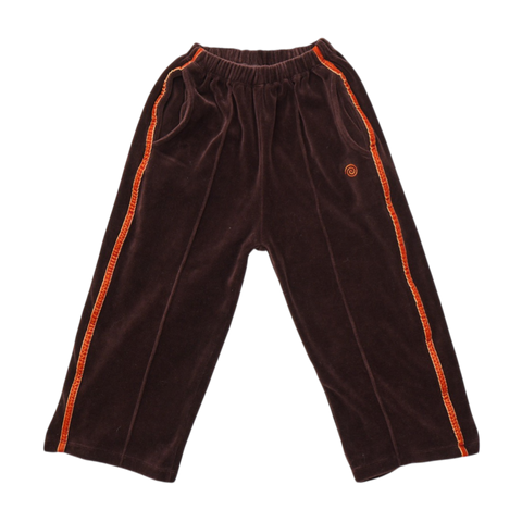 Brown velvet pants with orange trim and an orange swirl logo on a white background