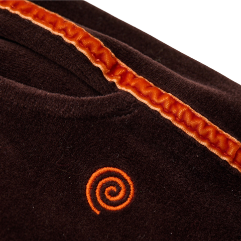 Brown velour pants with orange trim and orange swirl logo on a white background