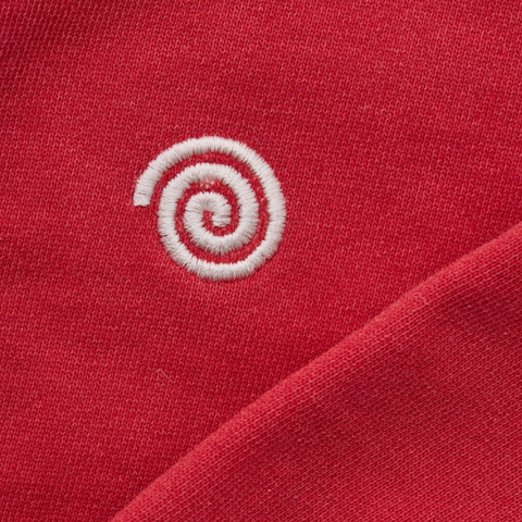 Close up of a red sweater with a white spiral logo