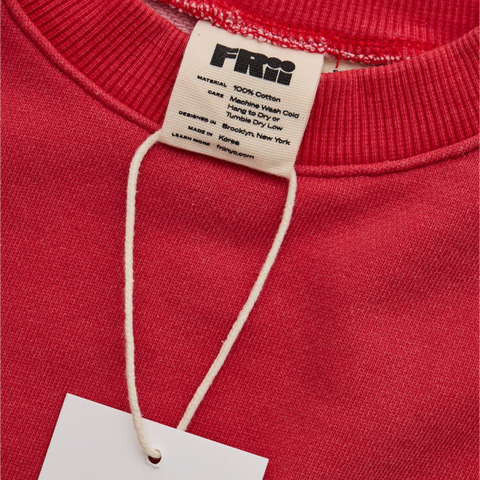 Red sweatshirt with a frii brand tag on a red background