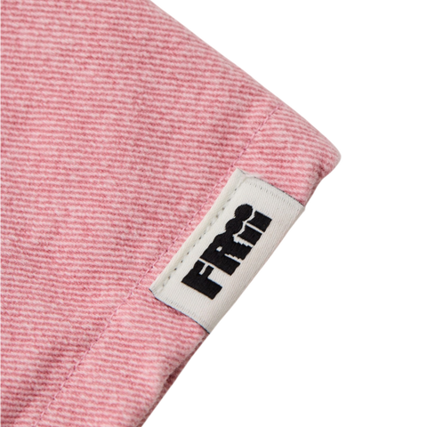 Close up of a pink textured pant with a visible frii brand label on a white background